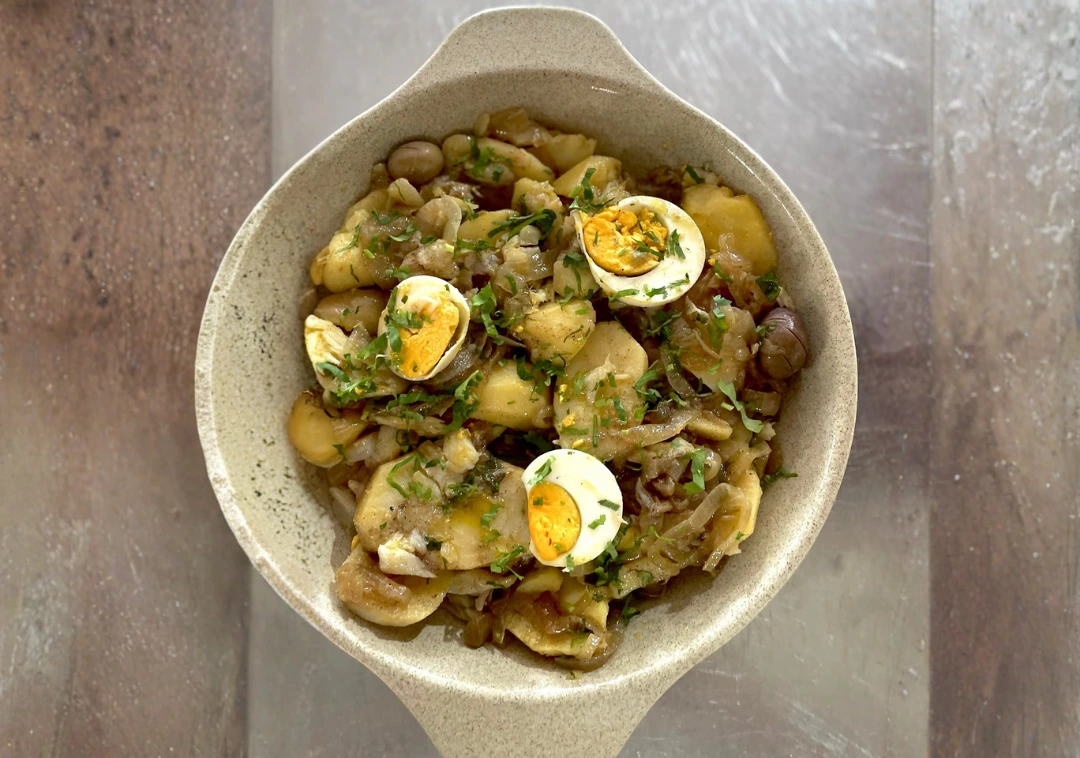 Taça de bacalhau com grão, ovo cozido e cebola