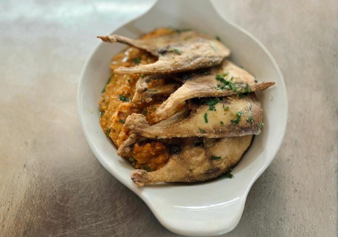 Peixinhos fritos servidos sobre arroz, em travessa branca
